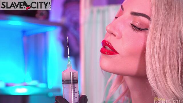 Blonde Nurse In A Green Latex Suit Offers To Give An Injection